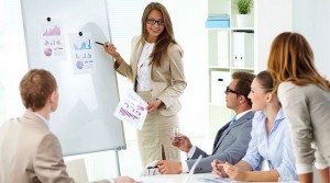 Confident businesswoman commenting marketing results to colleagues at meeting