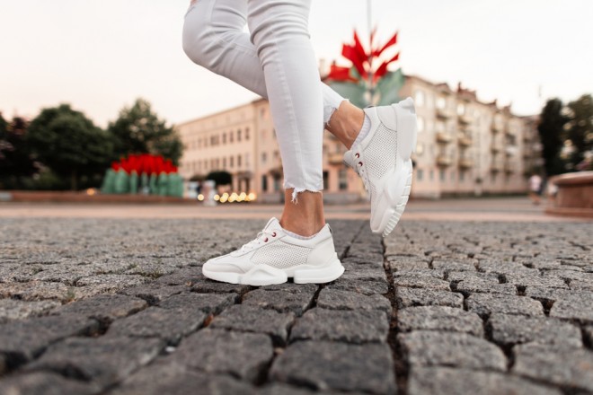Fashionable,White,Sneakers,On,Female,Legs,,Close-up.